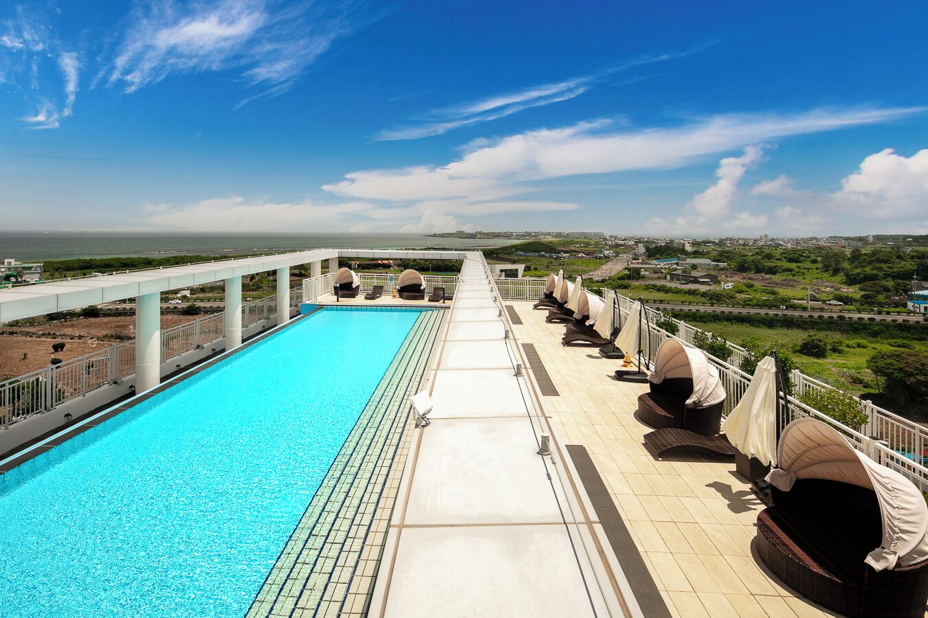 Una piscina en la azotea con vista despejada a la ciudad y al océano.