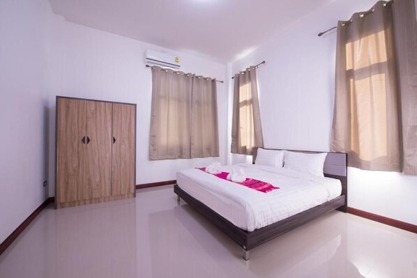 Quarto de hotel com cama, guarda-roupa e unidade de ar condicionado.