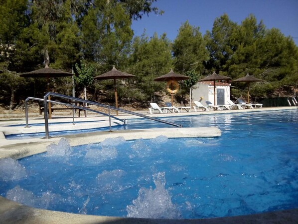 室外游泳池，池畔遮阳伞，日光浴躺椅