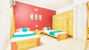 Ein Zimmer mit zwei Betten, einem Kleiderschrank und einem Spiegel.