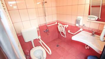 A bathroom with a toilet, sink, and shower.