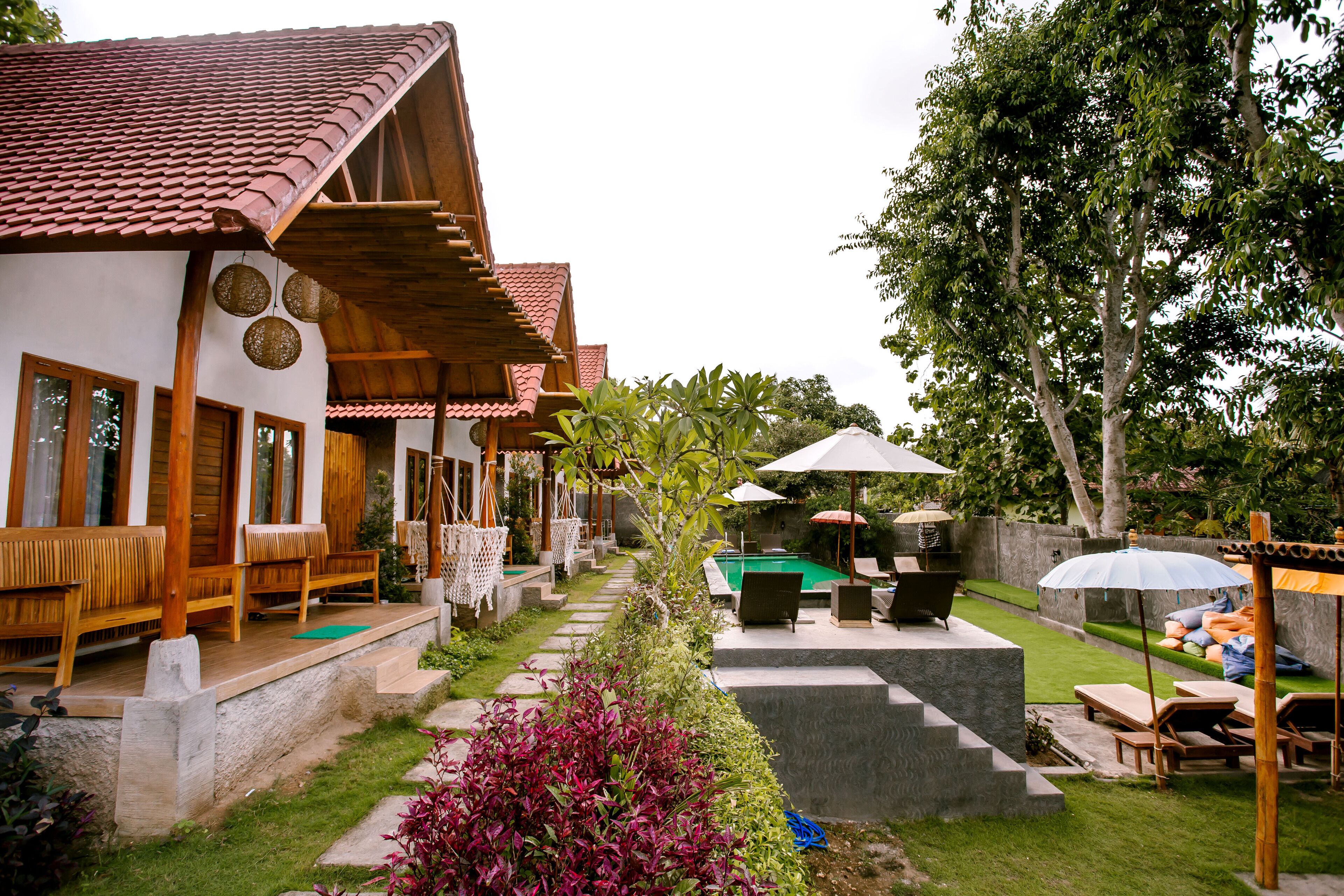 A resort with outdoor seating, a pool, and a well-maintained garden.