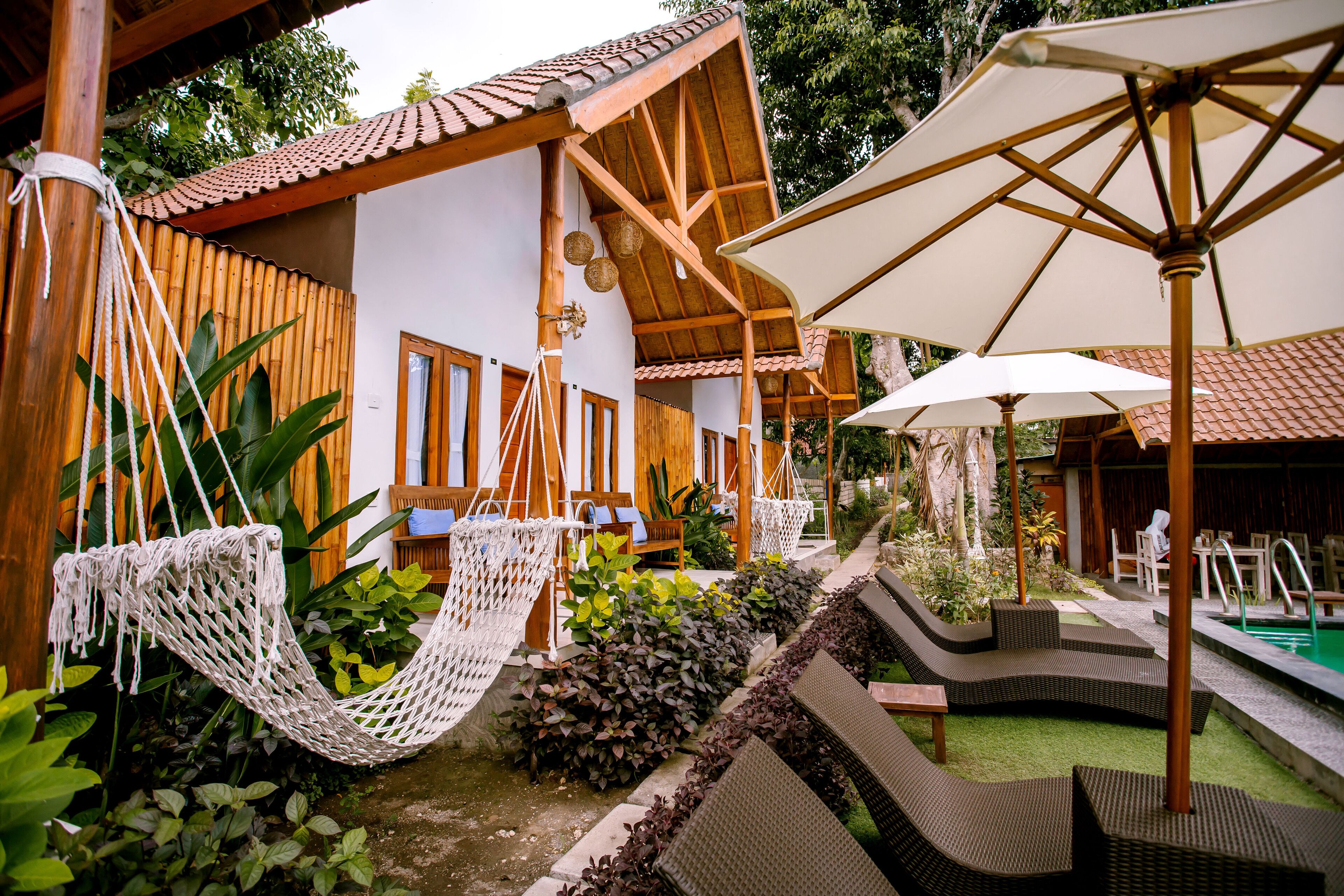 Ein Resort mit Außenbestuhlung, einem Pool und einer Holzkonstruktion.