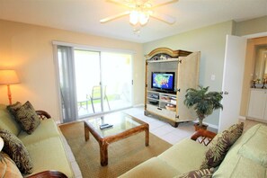 Relax in this inviting living room with a sofa, armchairs, and a TV.