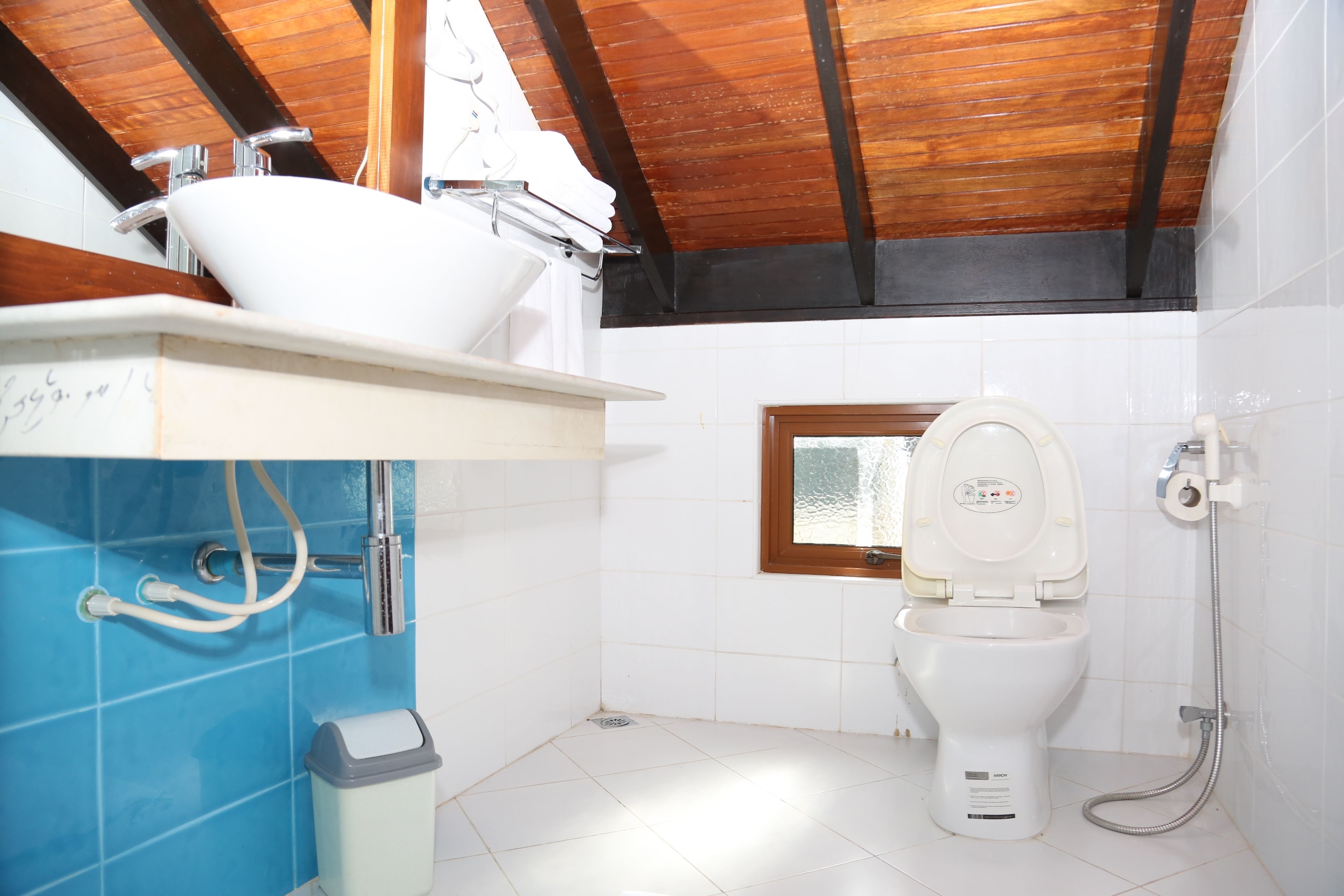 Un baño pequeño con inodoro blanco, lavamanos y ducha.
