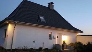Une maison de plain-pied avec un toit sombre et une petite fenêtre.