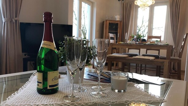 Une table à manger avec une bouteille de vin, deux verres à vin et une bougie.