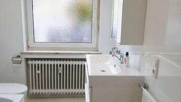 Een bad/douchecombinatie, een haardroger