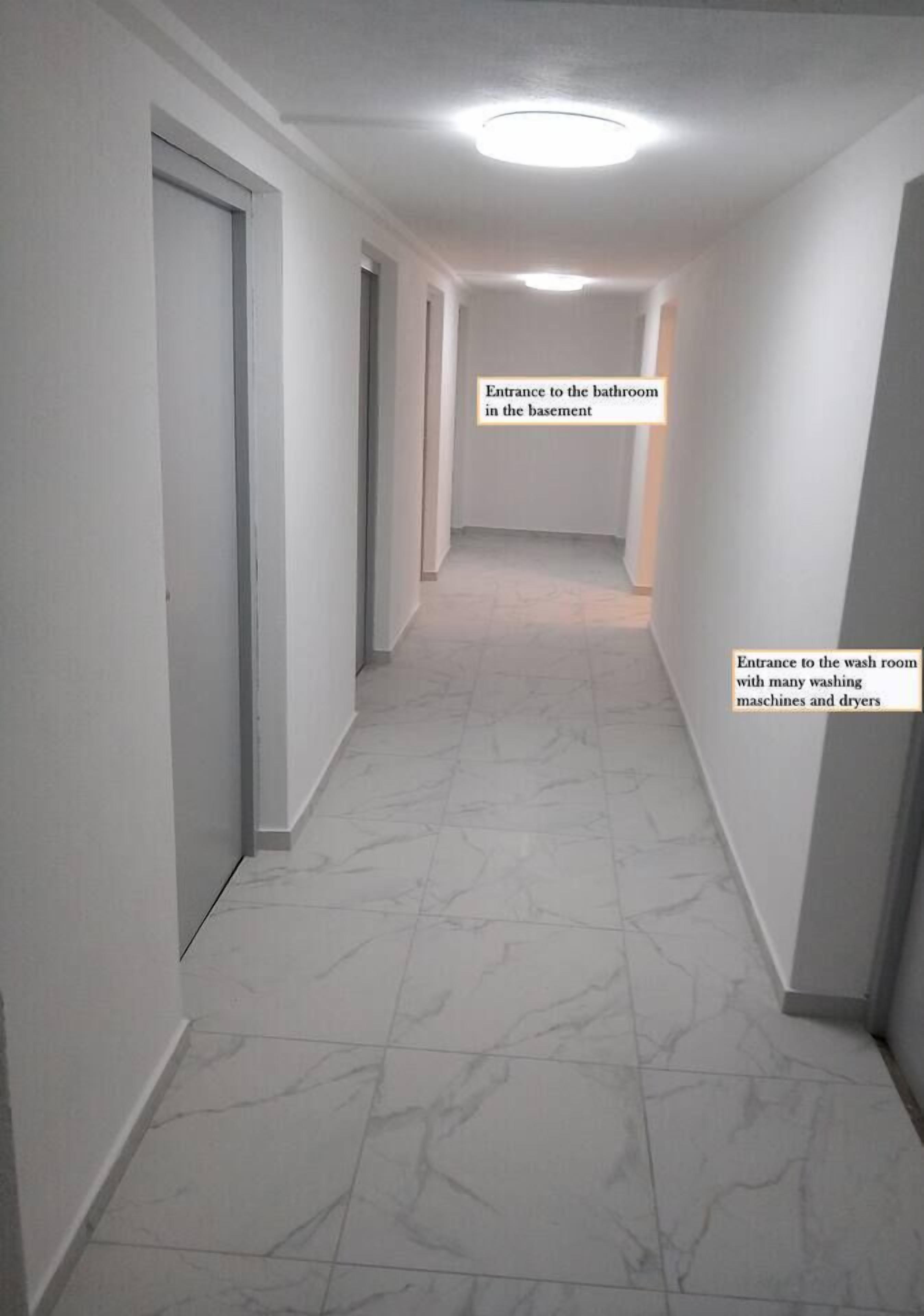 Im Keller gibt es ein Waschraum mit vielen Waschmaschinen und Trockner und ein gemeinsames Badezimmer