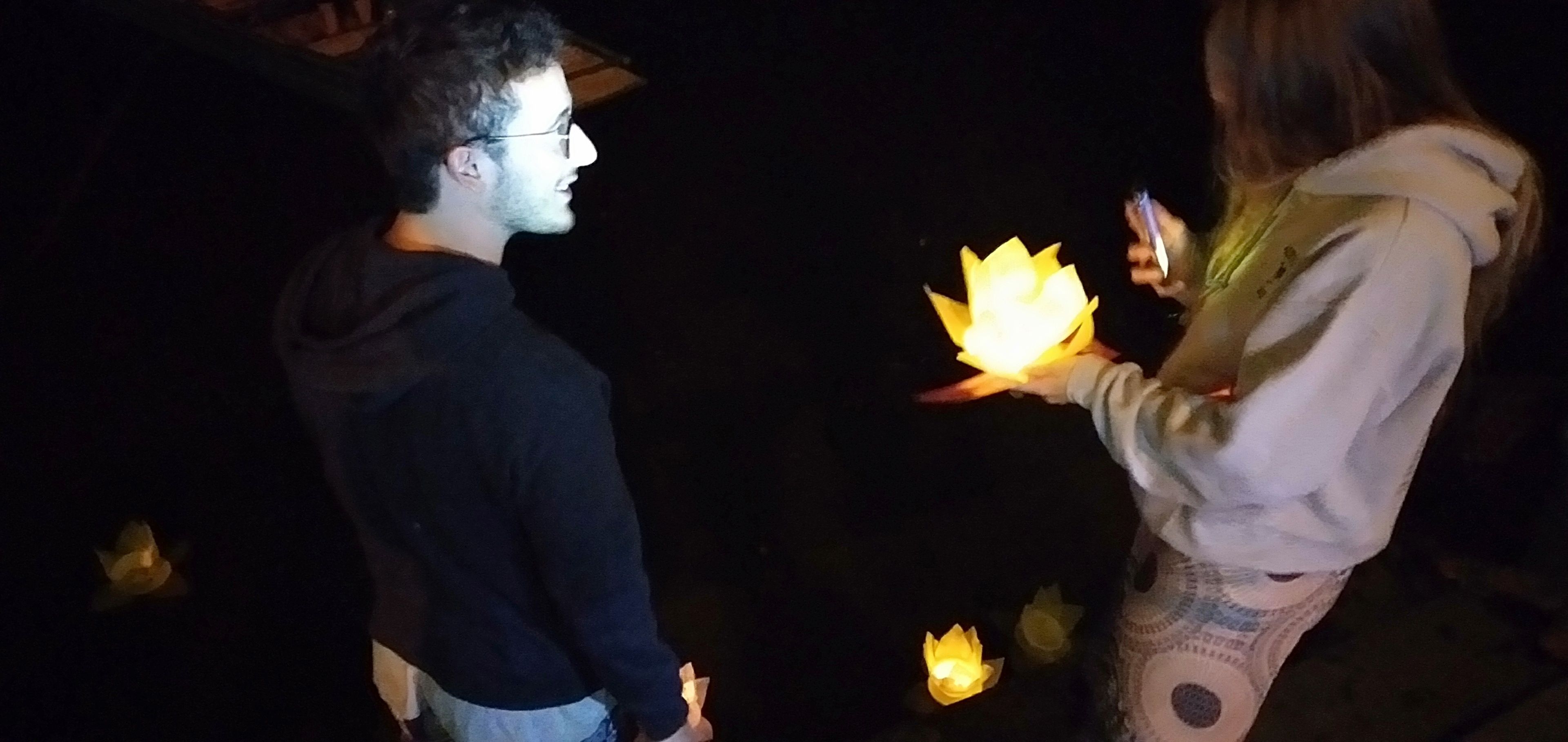 Dos personas sosteniendo farolillos iluminados.