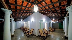 A spacious hall with a high ceiling and columns, featuring rows of chairs and a few doors. - Lagoon Bay Negombo (Negombo)