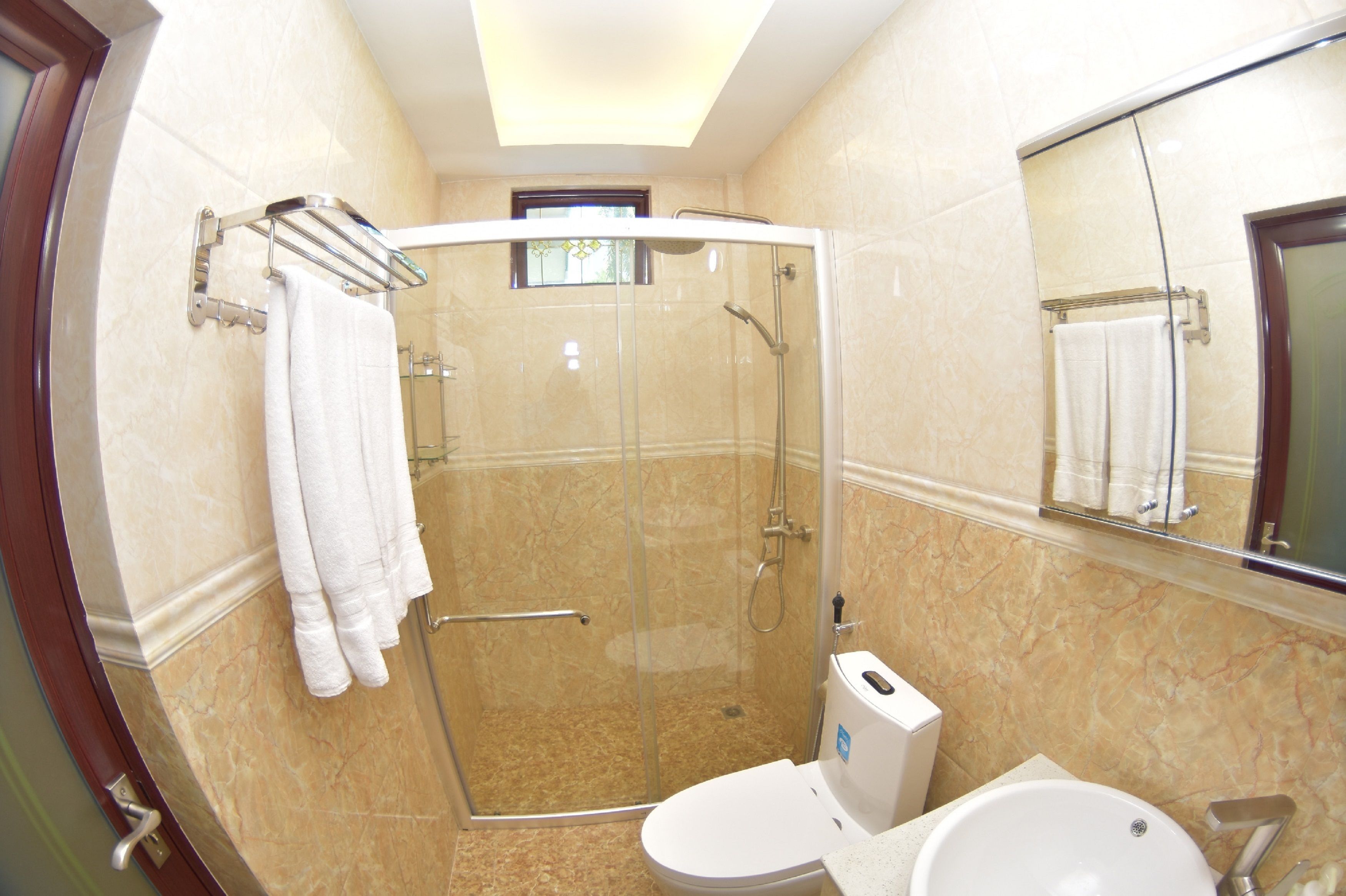A modern bathroom with a glass-enclosed shower, a toilet, and a sink.