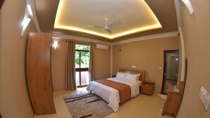 A bedroom with a bed, a nightstand, a mirror, a ceiling fan, and a window with curtains.
