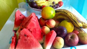 Una bandeja con frutas variadas, como sandía, manzanas y plátanos.