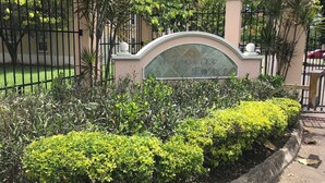 A well-maintained garden area with neatly trimmed bushes and a decorative sign. - Comfy and Secure  One Bedroom Apt- Sleeps 3!! (New Kingston)