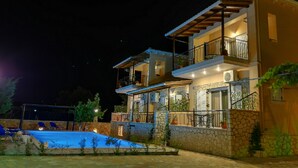 A two-story building with a swimming pool, stone walls, and balconies. - Alkionis (Lefkada)