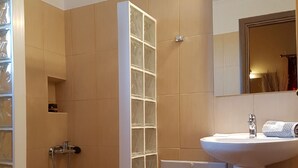 A bathroom with a glass shower enclosure, a sink, and a mirror. - Alkionis (Lefkada)