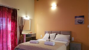 A bedroom with a bed, bedside tables, a nightstand, a mirror, and a painting on the wall. - Alkionis (Lefkada)