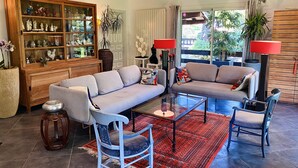 Un saló amb un sofà, cadires, una taula de centre i un moble decoratiu.