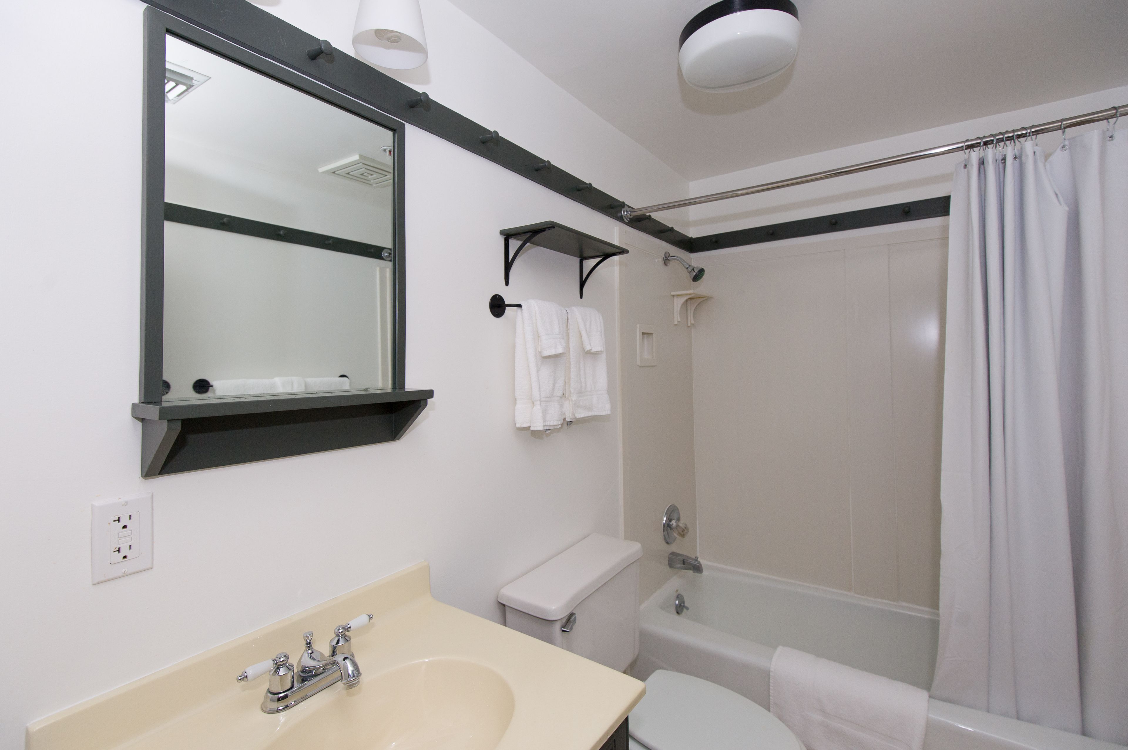 Un baño con lavamanos, inodoro y ducha.