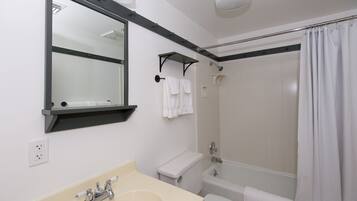 Un baño con lavamanos, inodoro y ducha.
