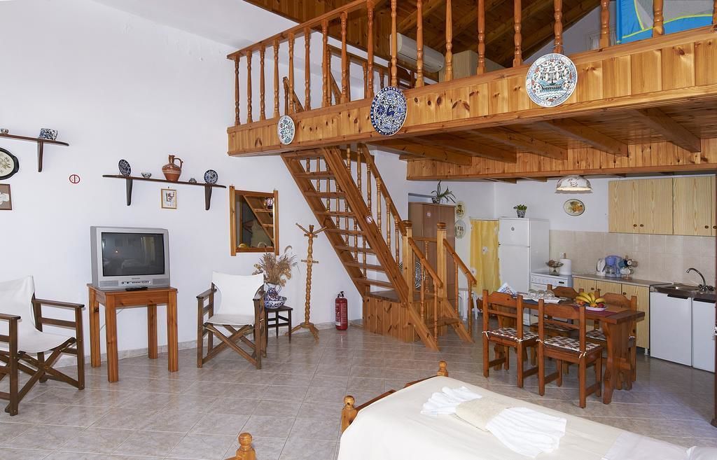 A spacious living area with a wooden staircase, a television, and a dining table.