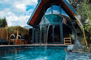 A modern house with a swimming pool, a glass water feature, and a wooden deck. - Adesa Bungalow Hotel (Sapanca)