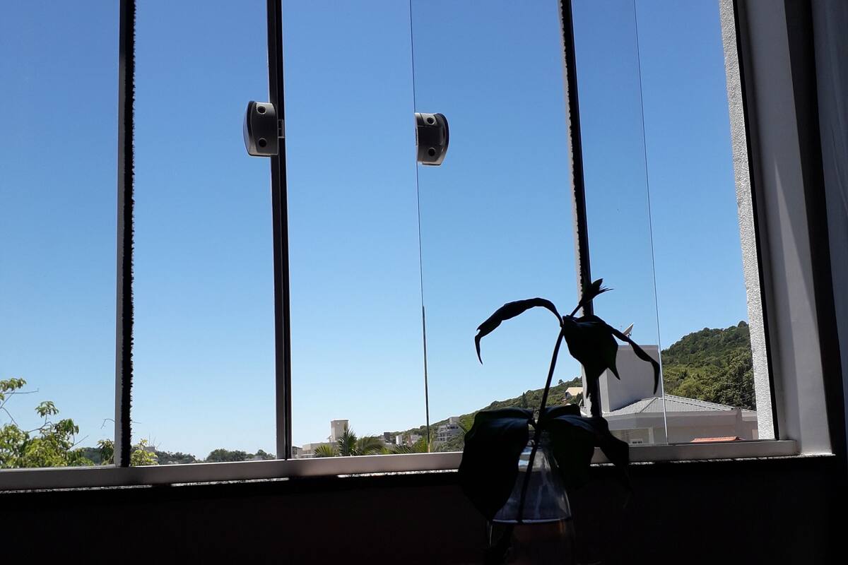 Una ventana con vista a un cielo azul despejado y un paisaje distante.