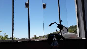A window with a view of a clear blue sky and a distant landscape.
