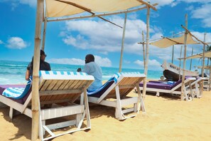 Playa privada, arena blanca, sillas reclinables de playa, sombrillas