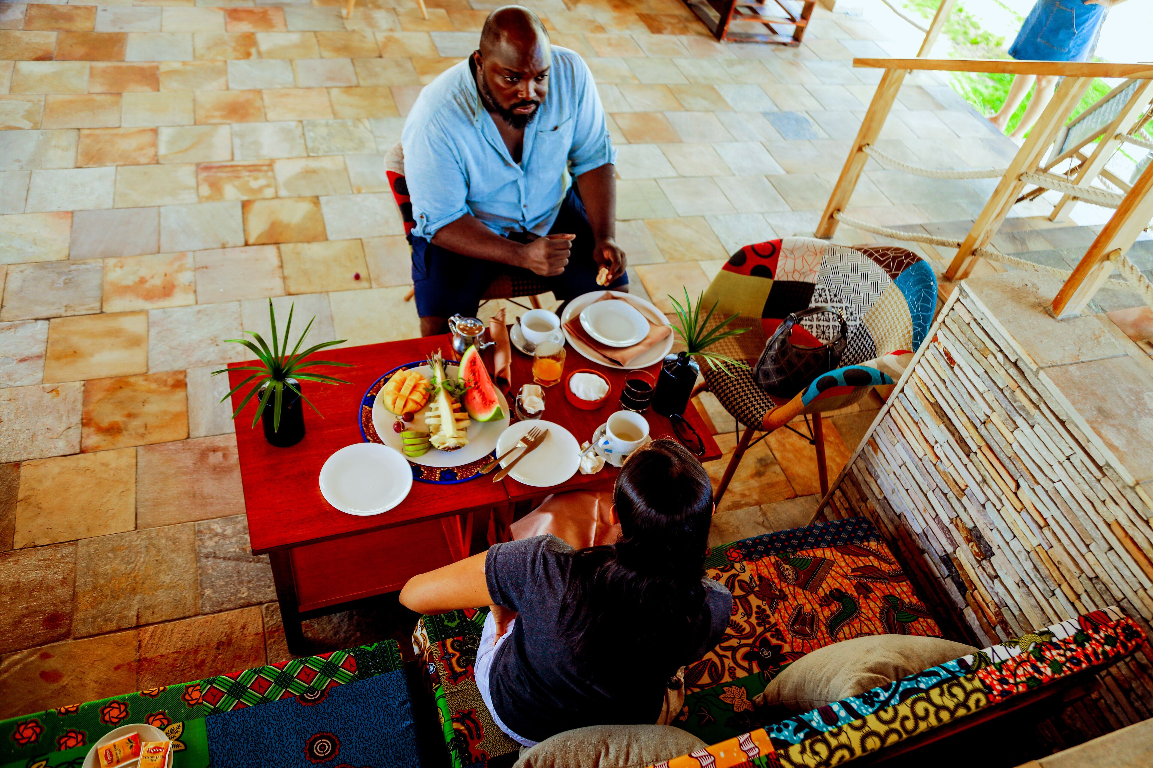 A dining area with a table set for two, featuring a variety of dishes and drinks.