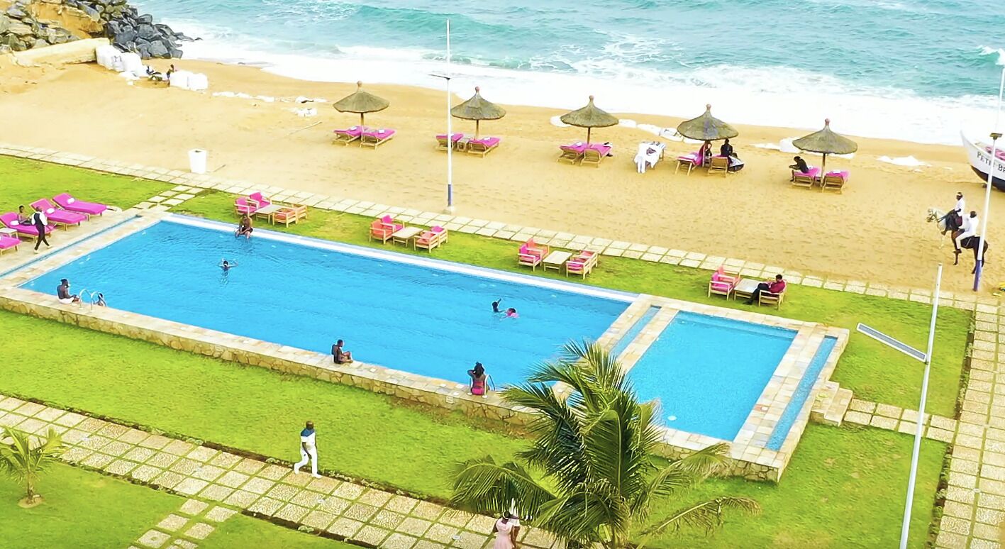 Una piscina al aire libre, sombrillas, tumbonas
