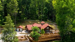 Un chalet comprenant plusieurs cabanes, un bâtiment principal et une terrasse en bois avec des sièges.