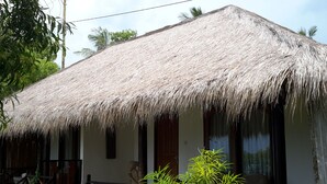 A thatched-roof building with a wooden staircase leading to a porch. - Hotel Gili Air & Restaurant (Gili Air)