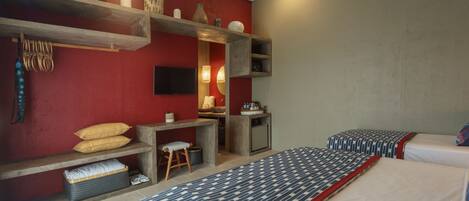 A compact hotel room with two beds, a desk, and a small kitchenette.