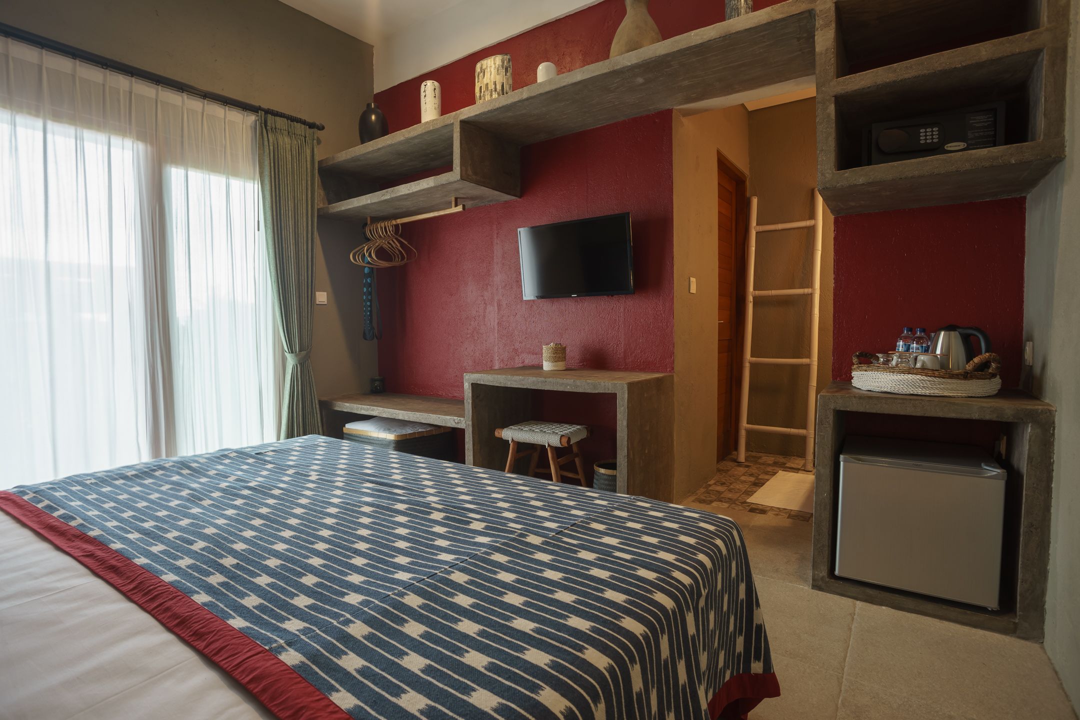 Une chambre d’hôtel équipée d’un lit, d’un bureau, d’une télévision et d’un réfrigérateur.