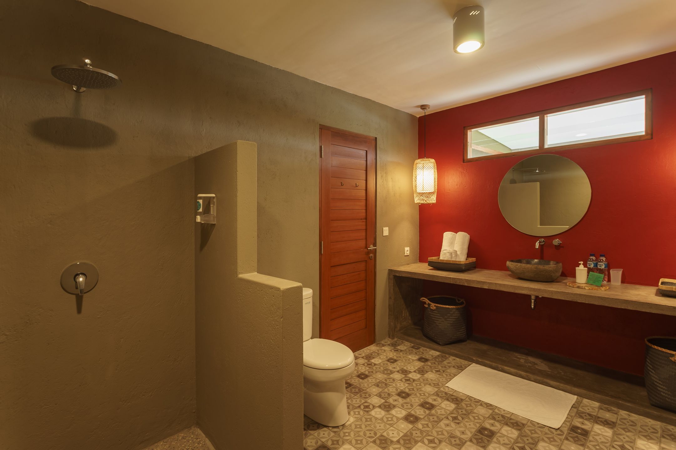 Une salle de bain équipée de toilettes, d’une douche, d’un lavabo et d’un miroir.