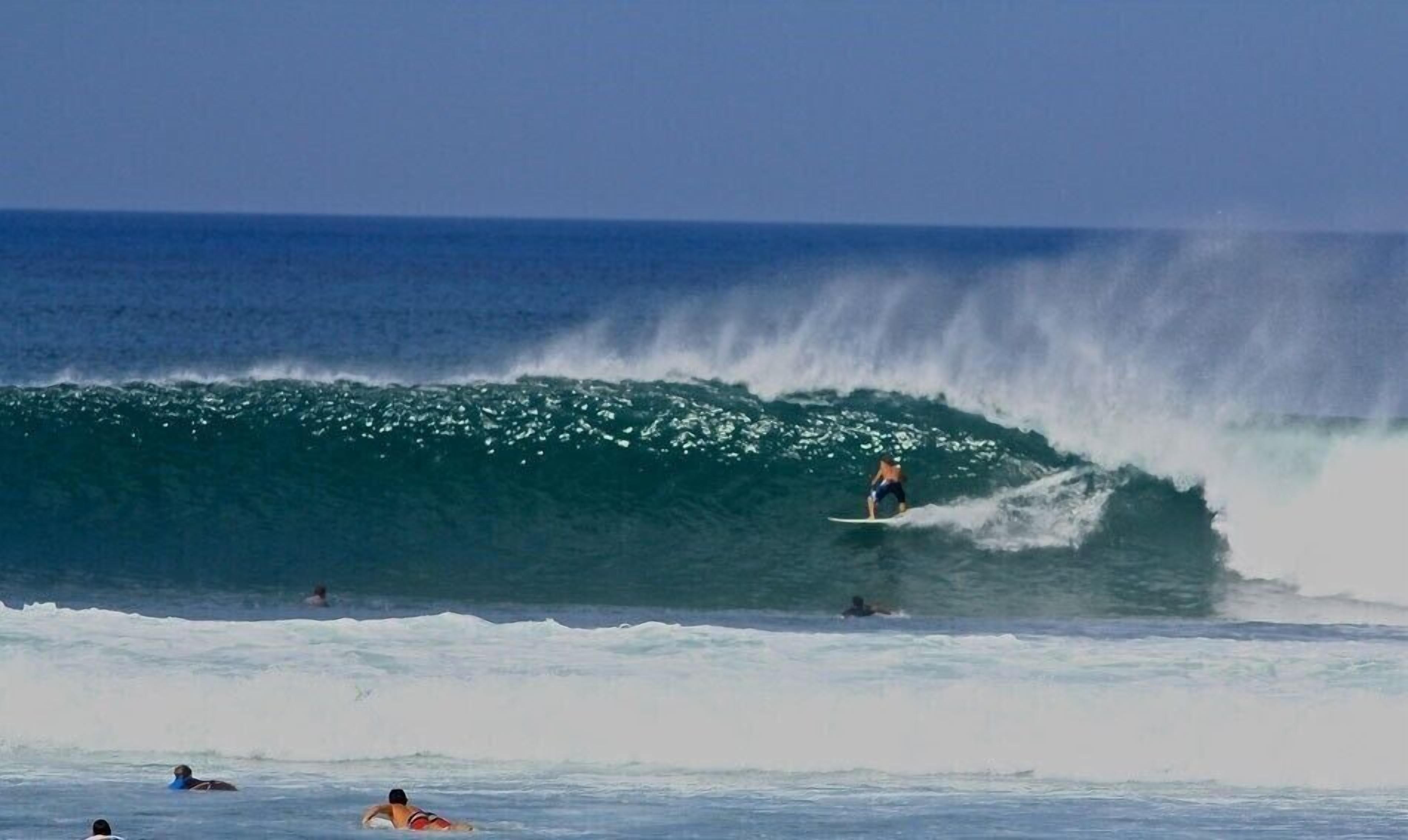 Un surfista montando una ola grande en el océano.