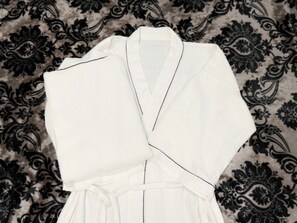 A white robe with black piping, laid out on a patterned fabric background. - Hotel Bali Bali Matsudo (Matsudo)