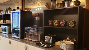Une cuisine moderne équipée d’un four à micro-ondes encastré, d’un grille-pain et d’une vitrine.