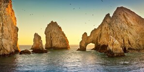 Experience the rugged beauty of a natural archway amidst towering rock formations.