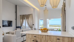 A modern living room with a wooden island, white sofas, and a large window with a view. - Villa LA LUNA 1ª Línea Playa (Denia)
