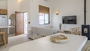 A modern living room with a dining area, a sofa, a TV, and a fireplace. - Villa LA LUNA 1ª Línea Playa (Denia)