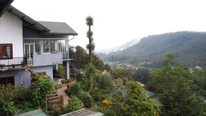 A two-story building with a balcony, surrounded by lush greenery and a view of a valley. - Misty Mountain Villas (Nuwara Eliya)