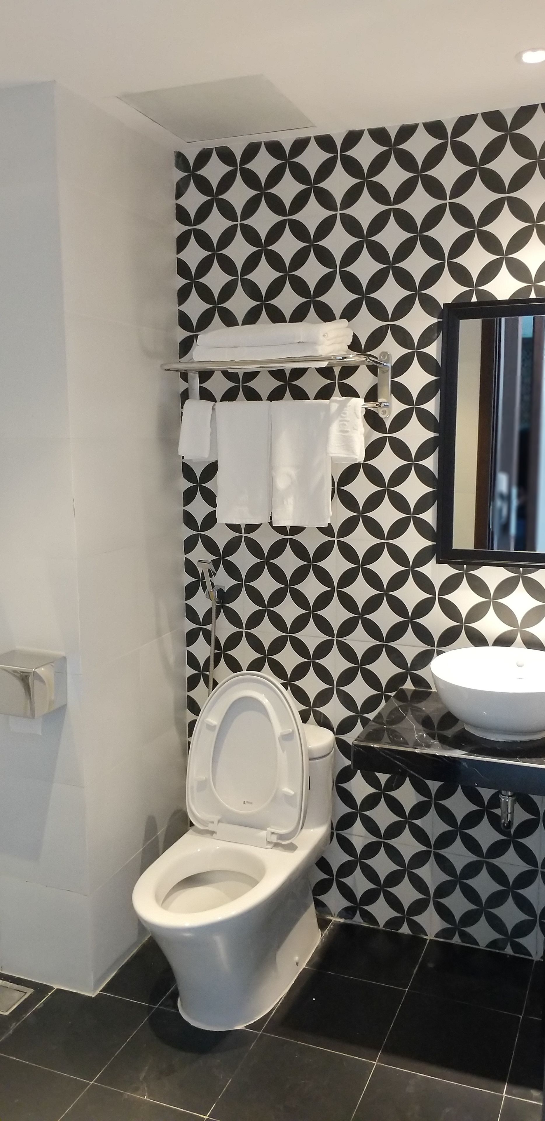 Un bagno con il water, un lavandino e un portasciugamani.