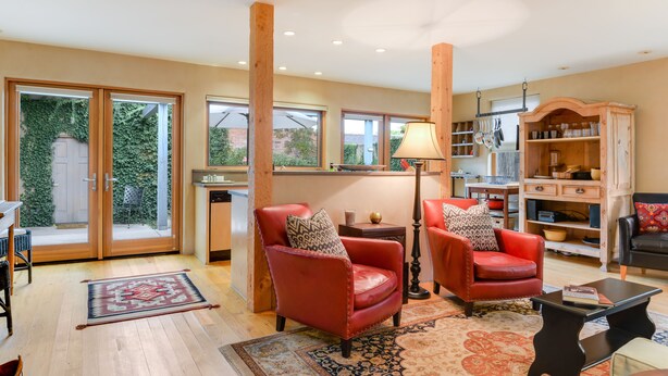 A spacious living room with leather armchairs, a coffee table, and a bookshelf.