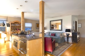 Enjoy a spacious living area with a kitchen, comfortable sofa set, and a coffee table.