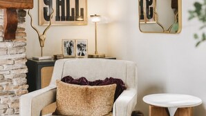 A cozy living room with a sofa, a round wooden side table, and a mirror on the wall. - Gatlinburg Cottage – Hot Tub, Walk Downtown (Gatlinburg)