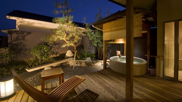 A wooden deck with a hot tub, a wooden chair, and a stone lantern. - Migiwaya (Yaizu)