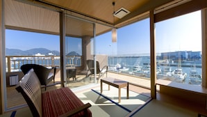 A balcony with a view of a marina, including boats and a distant mountain range. - Migiwaya (Yaizu)